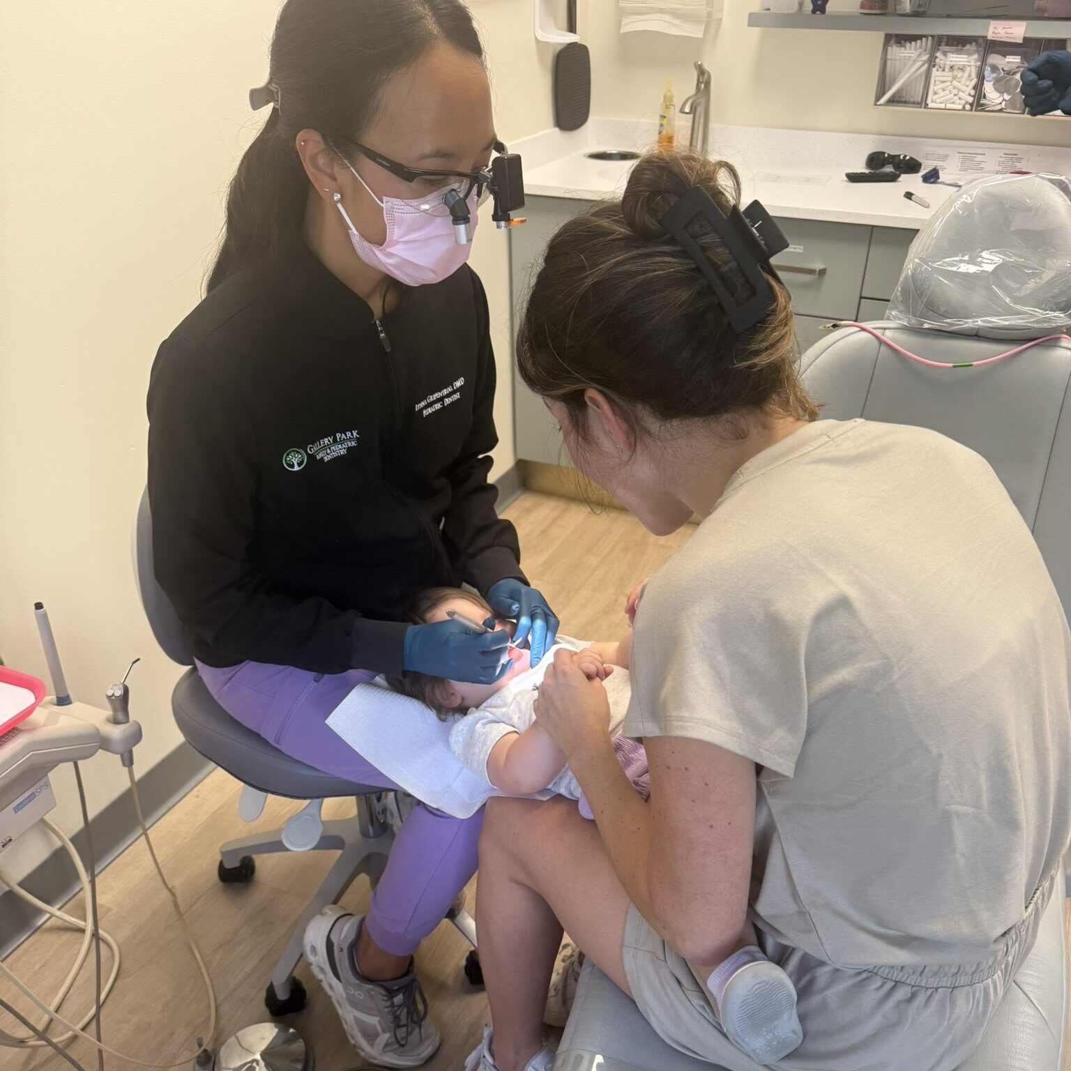Pediatric dentist doing a knee-to-knee exam on a toddler at Gallery Park Family and Pediatric Dentistry